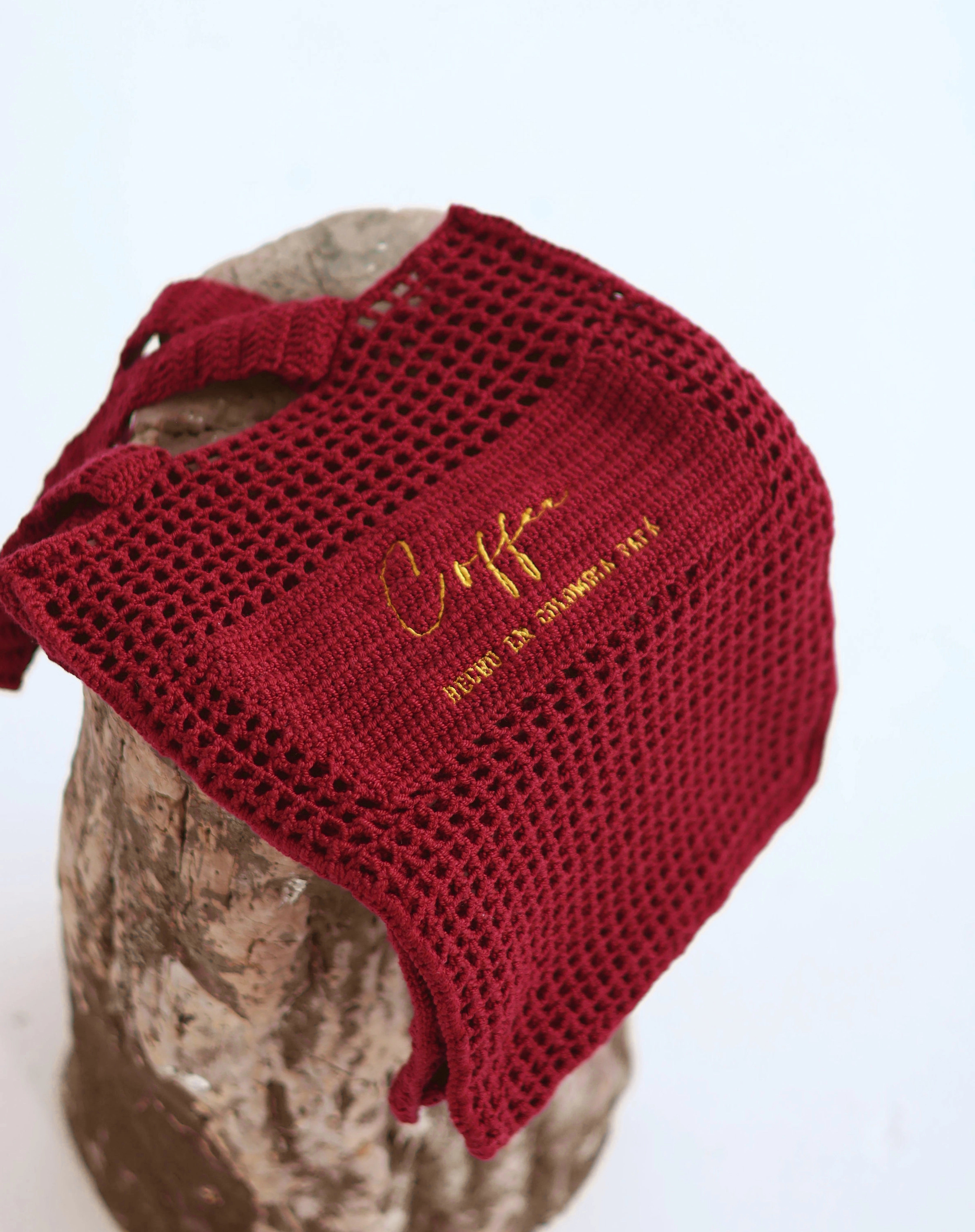 Bolso tipo tote en algodón orgánico tejido a mano, color cereza con la etiqueta "Café - Hecho en Colombia PAPA", diseño minimalista y sostenible diseñado por Coffee Clothing.